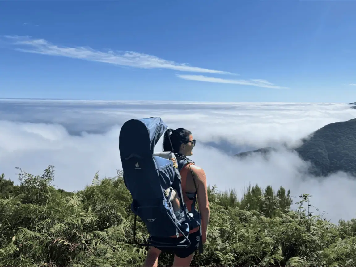 A mother carrying her baby in one of our hiking backpacks above the clouds in Madeira